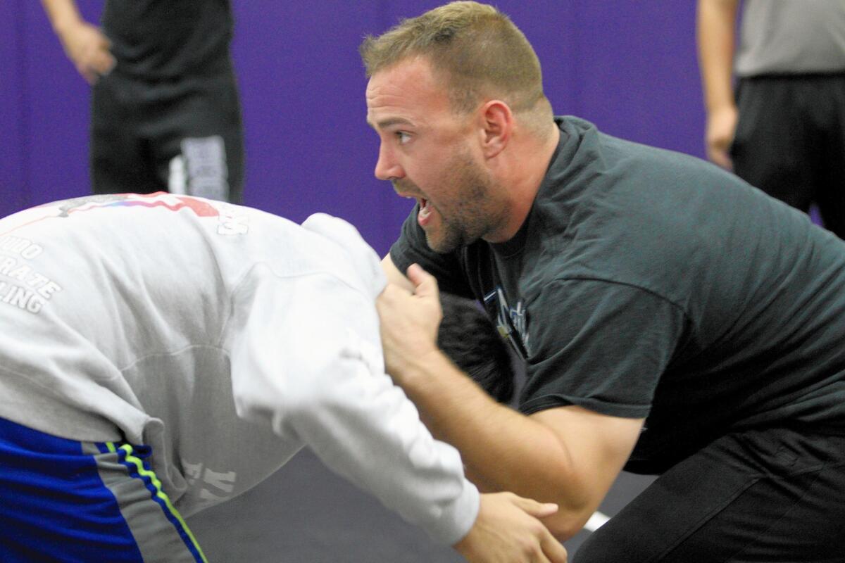 Hoover High School wrestling coach Dave Beard teaches the finer points of take-down moves during practice at the school's gym in Glendale on Friday, Nov. 20, 2015.