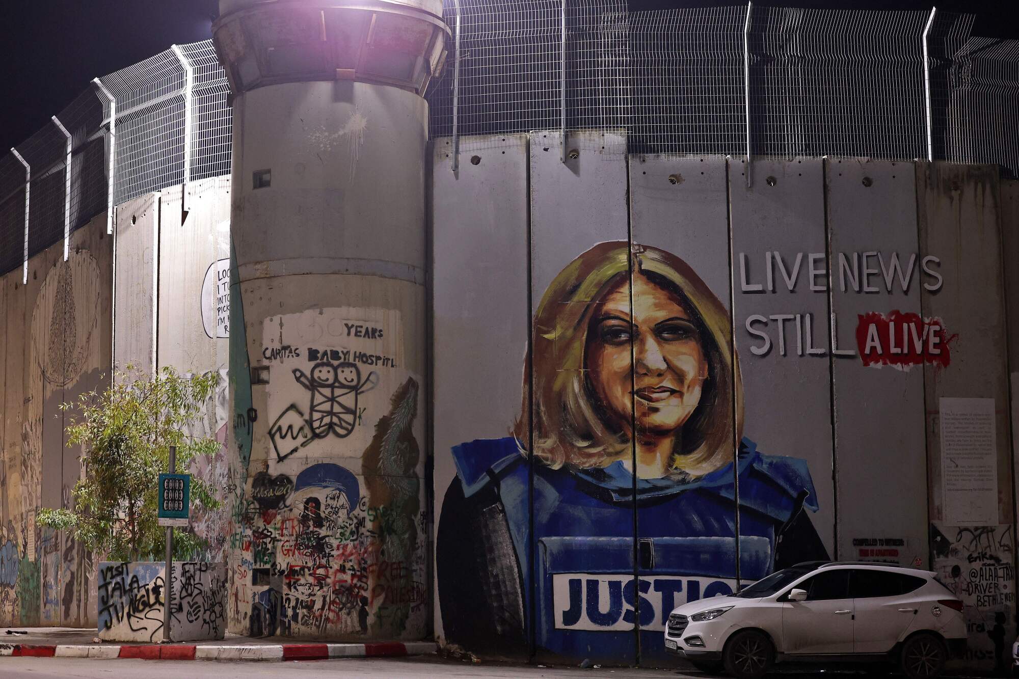 A  mural of a slain Palestinian-American journalist on a section of Israel's separation fence in the occupied West Bank.