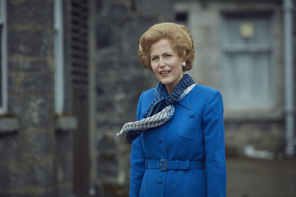 A woman outside in blue coat with a blue scarf