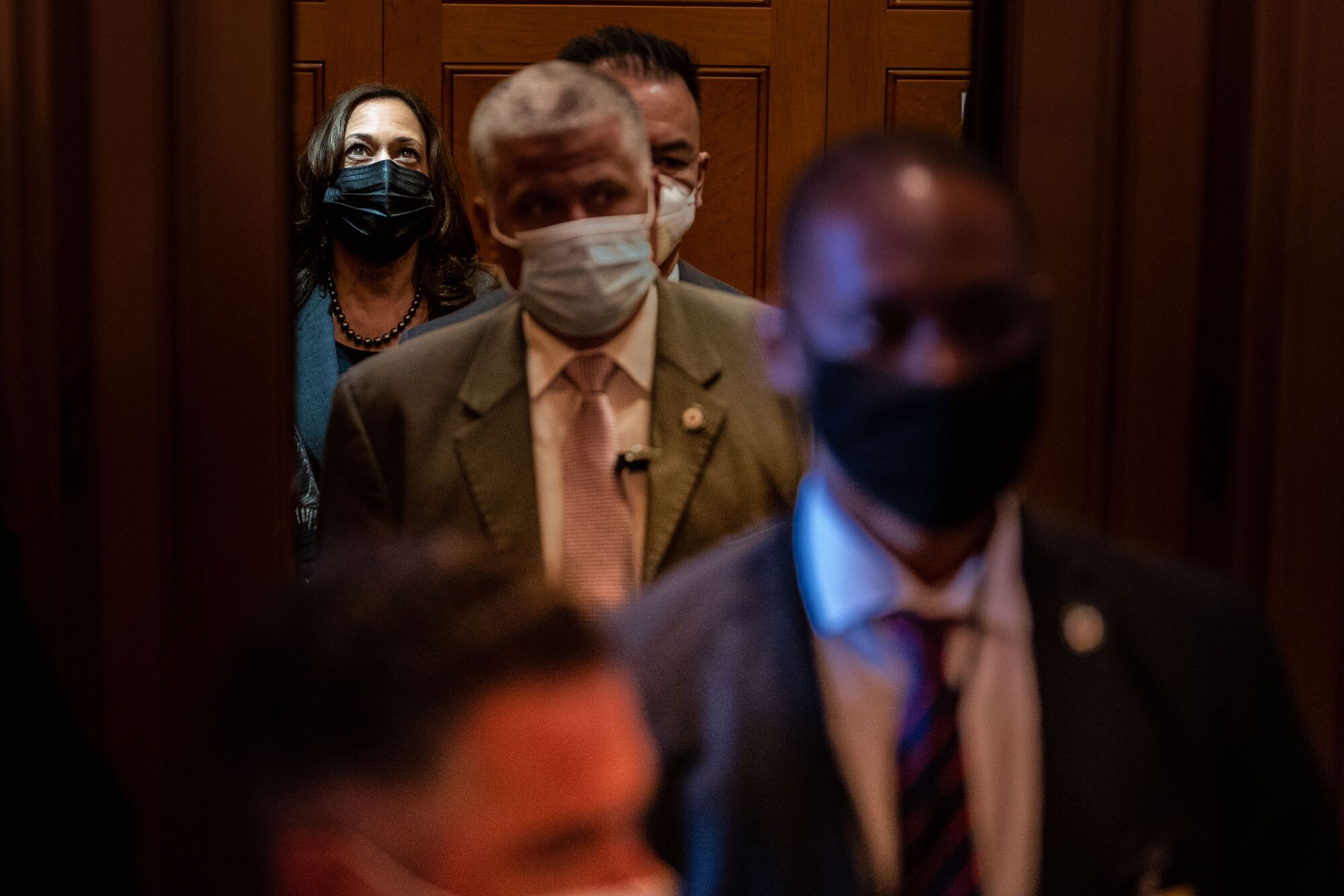 Kamala Harris stands in an elevator as others leave