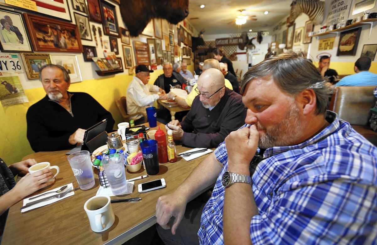 Bakersfield oil workers gather at Pappy’s Coffee Shop before work. Consultant Roger Lake, left, has worked in the industry since 1959. At right, Ryan Williford, has had to lay off 30 workers from his drilling rig service company.