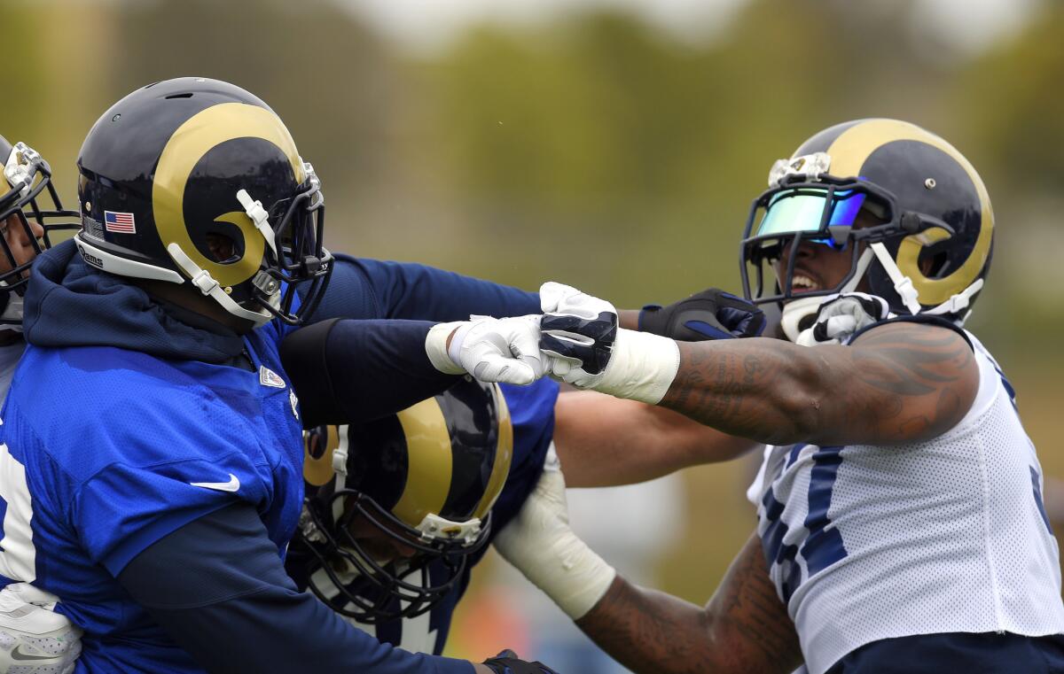 Rams tackle Greg Robinson, left, and defensive end Eugene Sims scuffle during practice on June 14 in Oxnard.