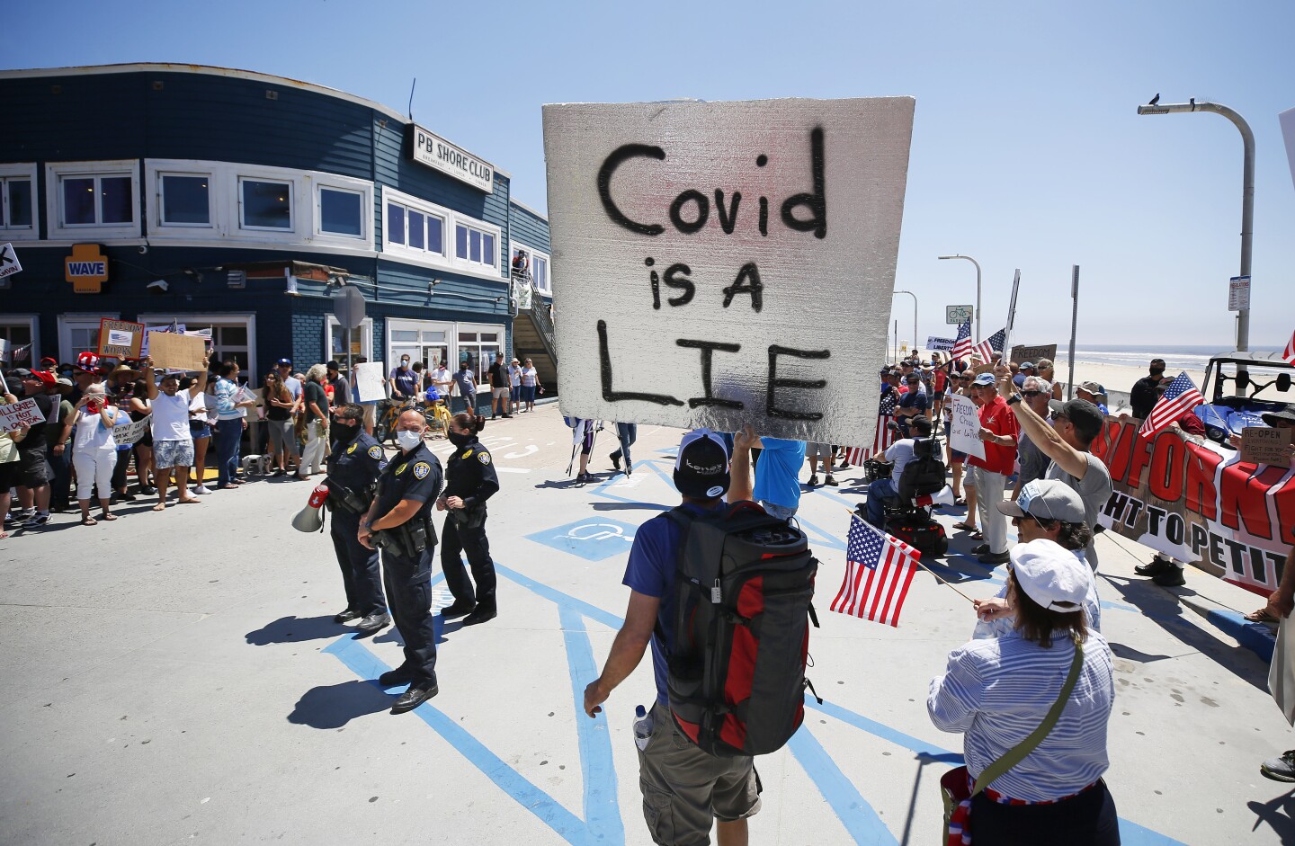 Protesters gather near the boardwalk in Pacific Beach during A Day of Liberty rally on Sunday, April 26, 2020. The protesters were against the government shutdown due to the coronavirus.