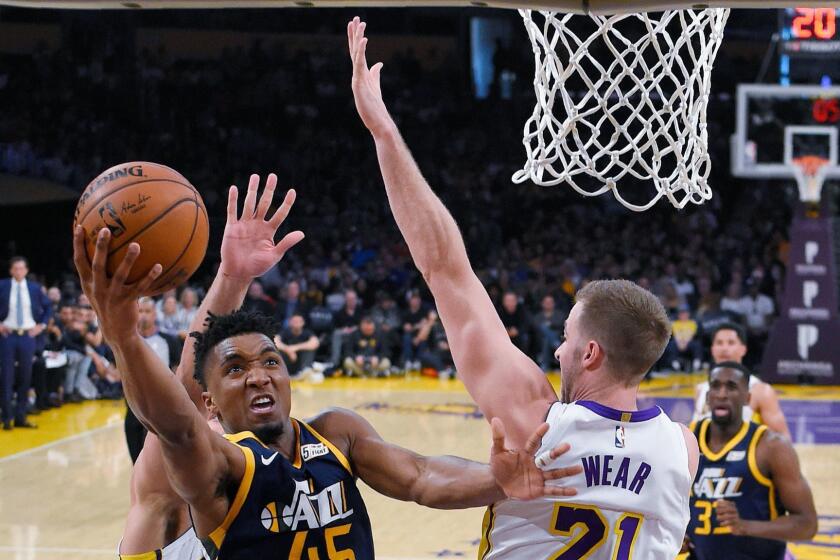 Utah Jazz guard Donovan Mitchell, left, shoots as Los Angeles Lakers forward Travis Wear defends during the first half of an NBA basketball game Sunday, April 8, 2018, in Los Angeles. (AP Photo/Mark J. Terrill)
