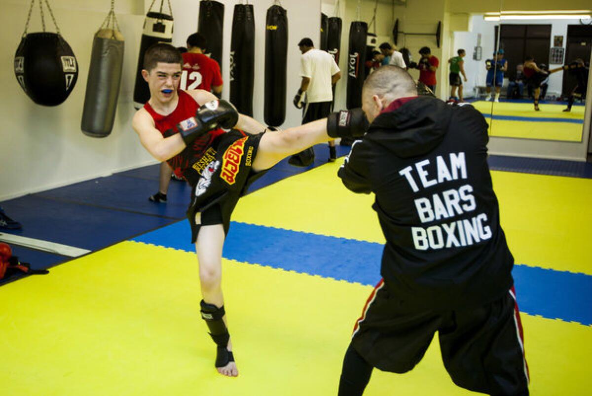 Reshat Mati delivers a blow to trainer Akmal Zakirov during a kickboxing session at Bars gym. Reshat's father, Adrian, grew up in Albania and introduced combat sports to his children after immigrating to the U.S. and starting a family with his wife, Ajshe. "There were no video games," Adrian says of life in Albania. "The only thing we had was wrestling and boxing."