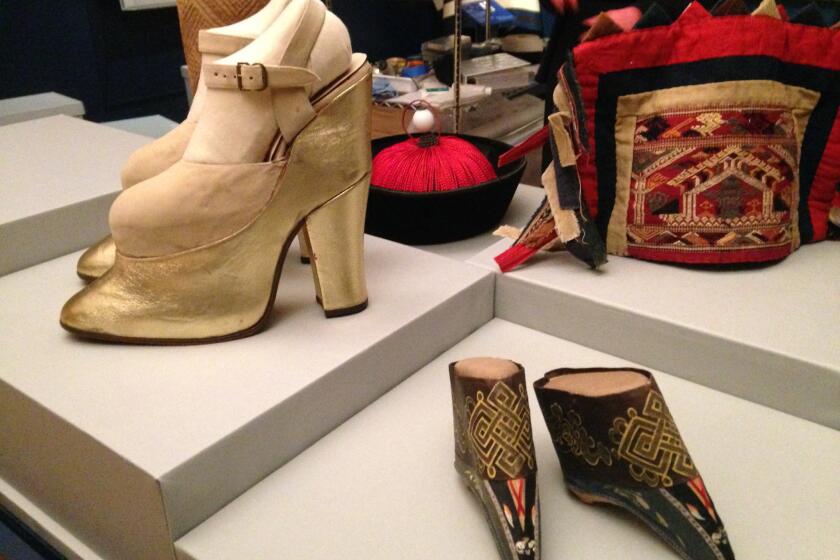 Platform shoes worn by actress Mae West in the 1950s were used to increase her height by more than 8 inches. In the foreground,shoes for a Manchu noblewoman from China that date to the late 19th century. Both are on display at the Foggy Bottom museum that opened Monday.