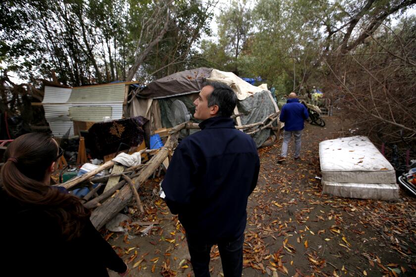 ENCINO, CA - DECEMBER 15, 2016: Mayor of Los Angeles Eric Garcetti talks with in a homeless encampment around the Sepulveda Basin in Encino, CA December 15, 2016. Mayor Garcetti toured encampments around the Sepulveda Basin Thursday, preparing for winter rainstorms. The visit is also part of the Mayor's regular homeless outreach efforts, where he regularly tours areas across the City with high concentrations of homeless residents. (Francine Orr/ Los Angeles Times)