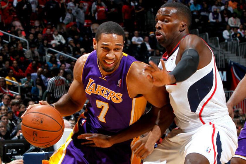 Lakers swingman Xavier Henry, left, drives against Hawks guard Shelvin Mack during a game in December.