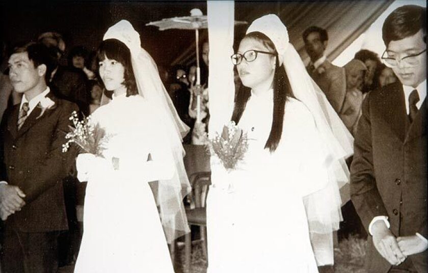 Nguyen The Hung and Nguyen Thiskieu Anh stand with Nguyen Thi Tuiet Oanh and Phueng Van Hao, from left, during a double wedding ceremony at Camp Pendleton. See full story