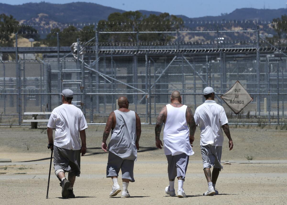 Inmates walk the exercise yard at a prison