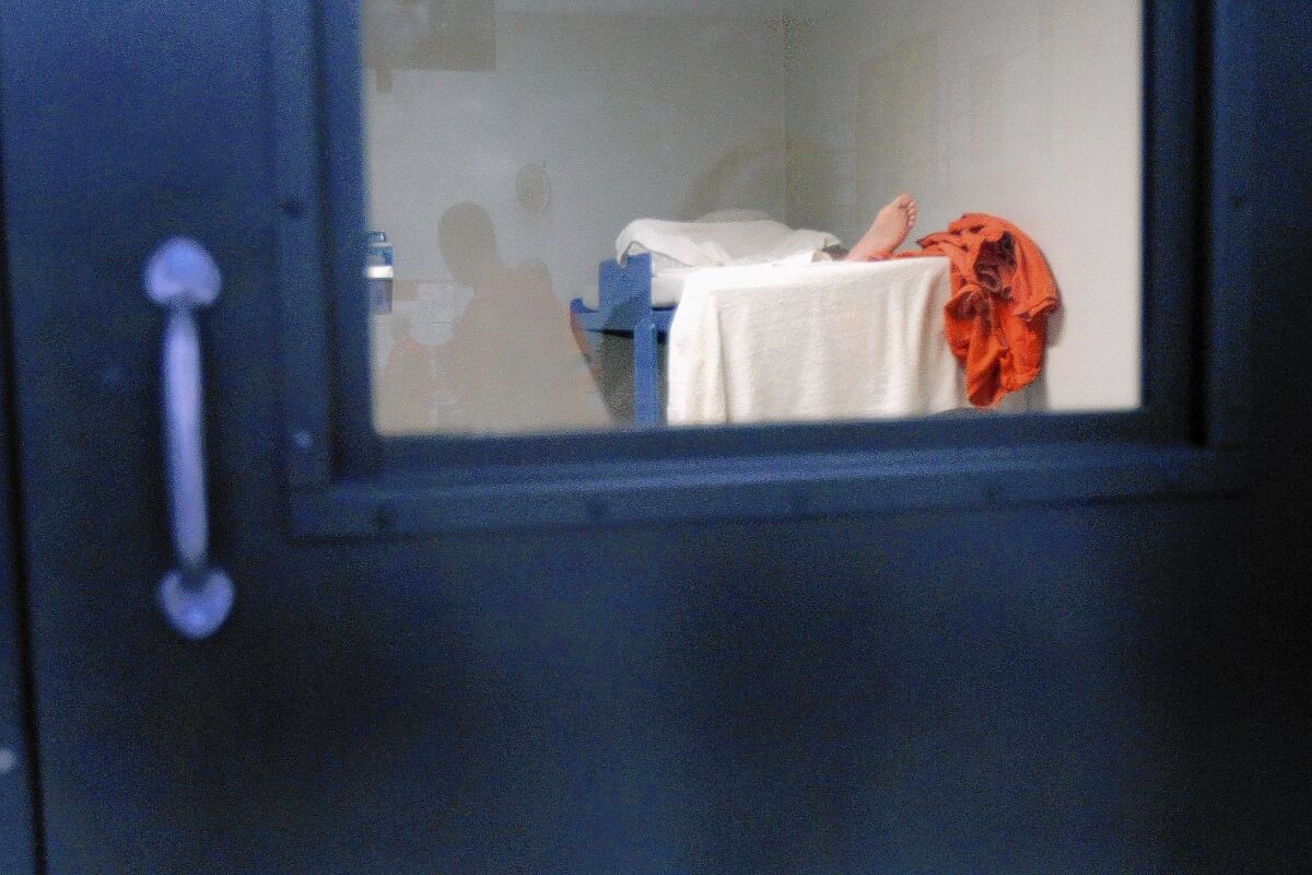 A detainee sleeps in his cell at the immigrant detention facility in Adelanto, Calif.