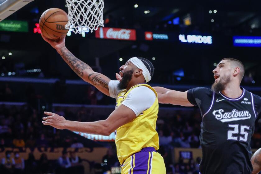 Los Angeles Lakers forward Anthony Davis (3) goes to basket under pressure from Sacramento Kings center Alex Len (25) during the first half of an NBA basketball game in Los Angeles, Friday, Nov. 26, 2021. (AP Photo/Ringo H.W. Chiu)
