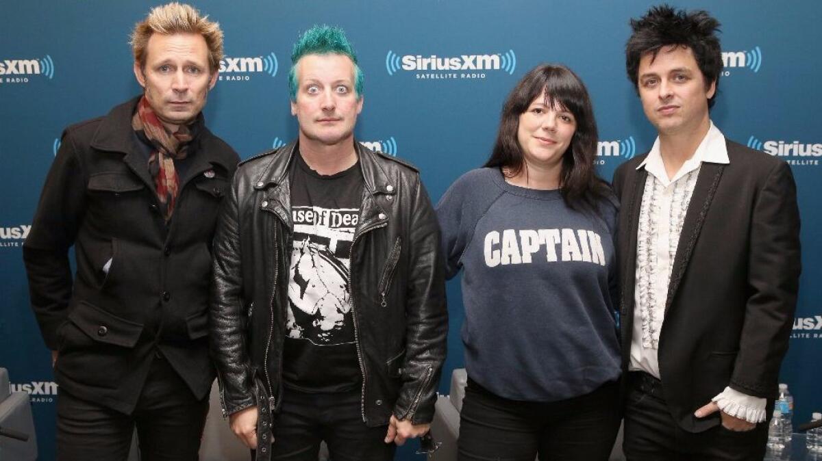 Mike Dirnt, Tre Cool, and Billie Joe Armstrong of Green Day pose with SiriusXM host Jenny Eliscu during SiriusXM's Oct. 7 "Town Hall" With Green Day.