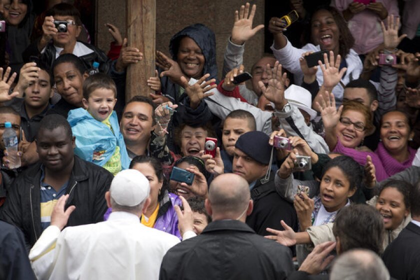 People greet and take pictures of Pope Francis as he visits the Varginha favela in Rio de Janeiro on Thursday.