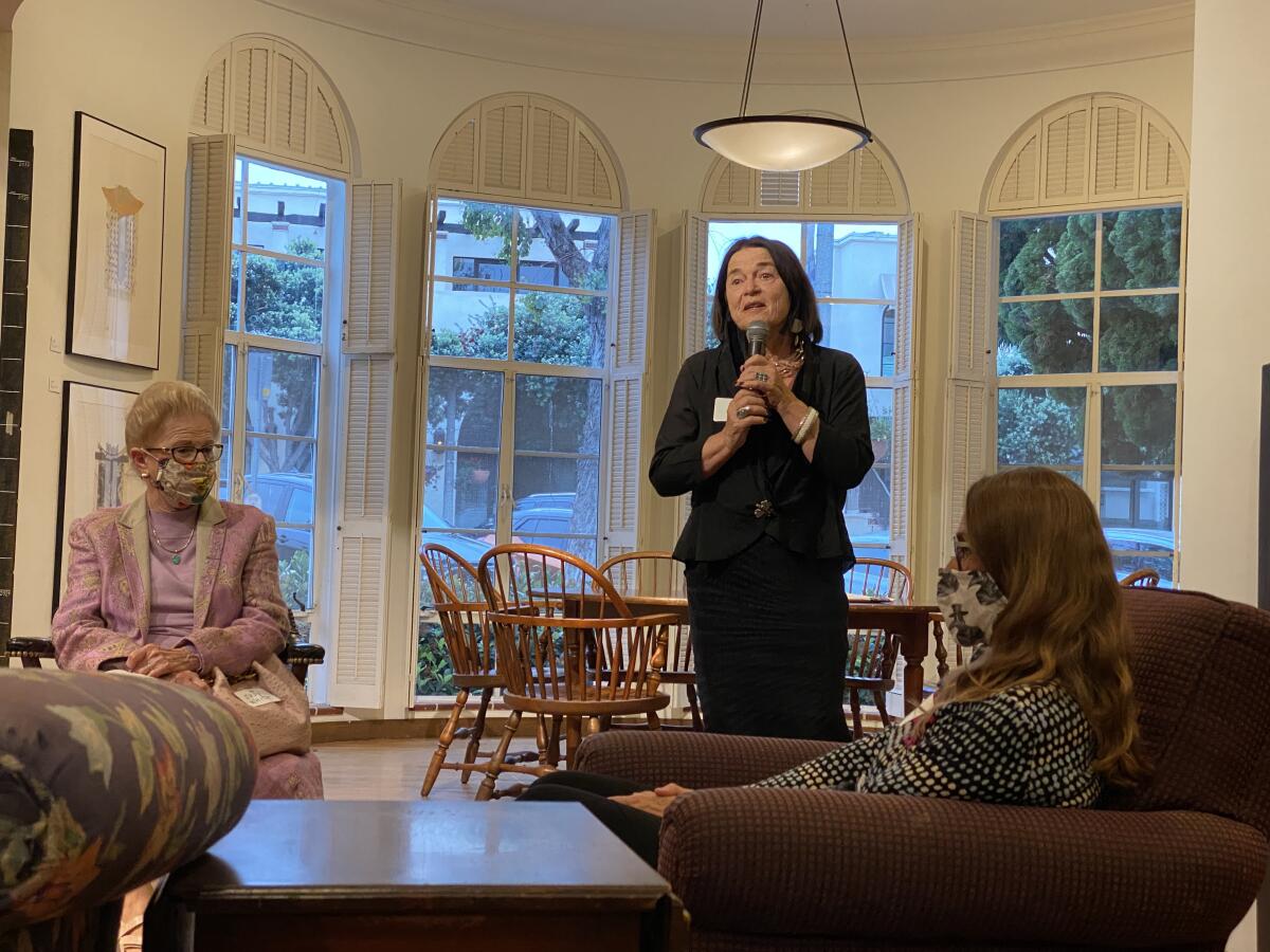 Athenaeum Executive Director Erika Torri speaks to artists and guests during the opening reception for "Marking Time."