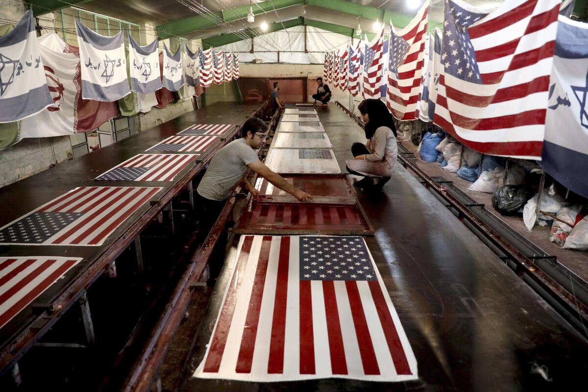 Workers at a factory near Khomein, Iran, help produce flags on Saturday.