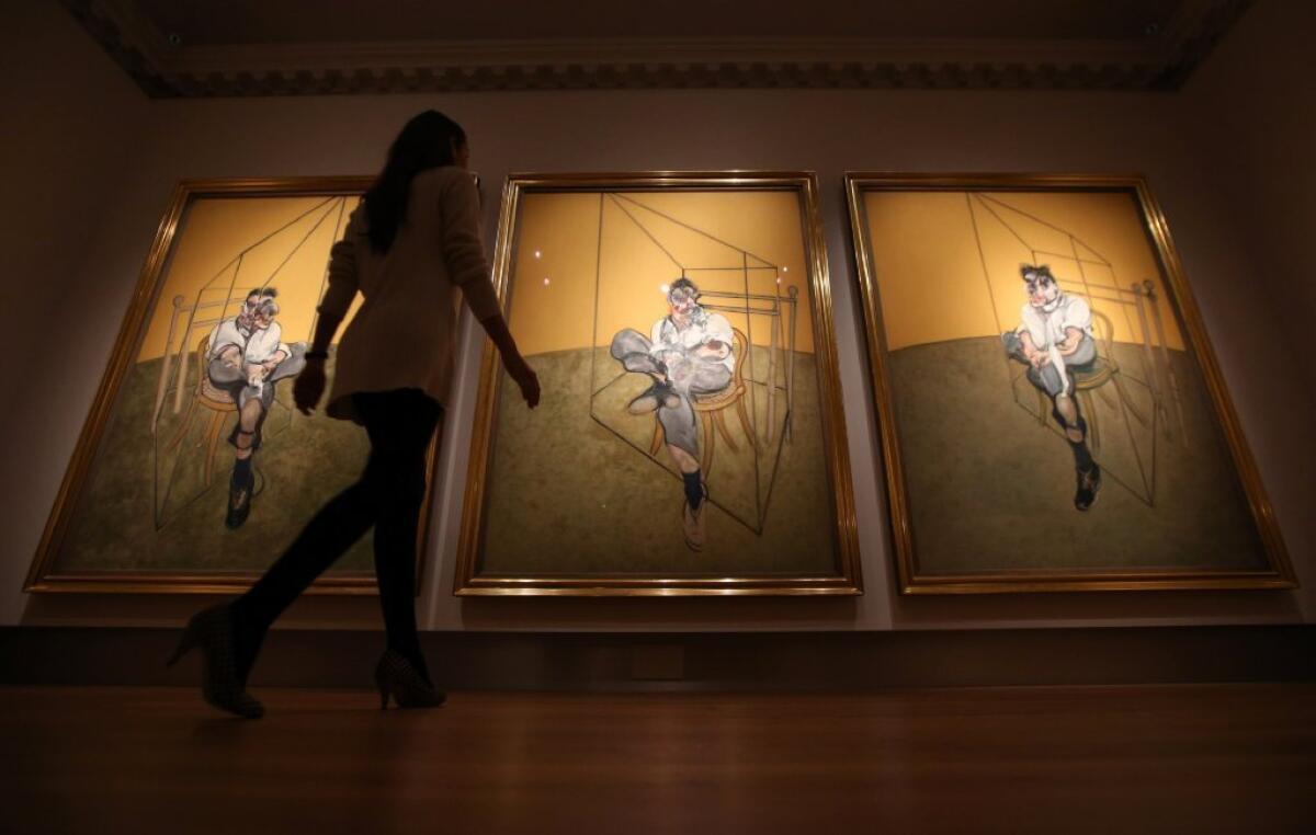 A staff member of Christie's in London walks past Francis Bacon's triptych of artist Lucian Freud last year. It later fetched $142 million, the highest auction price to date for an artwork.