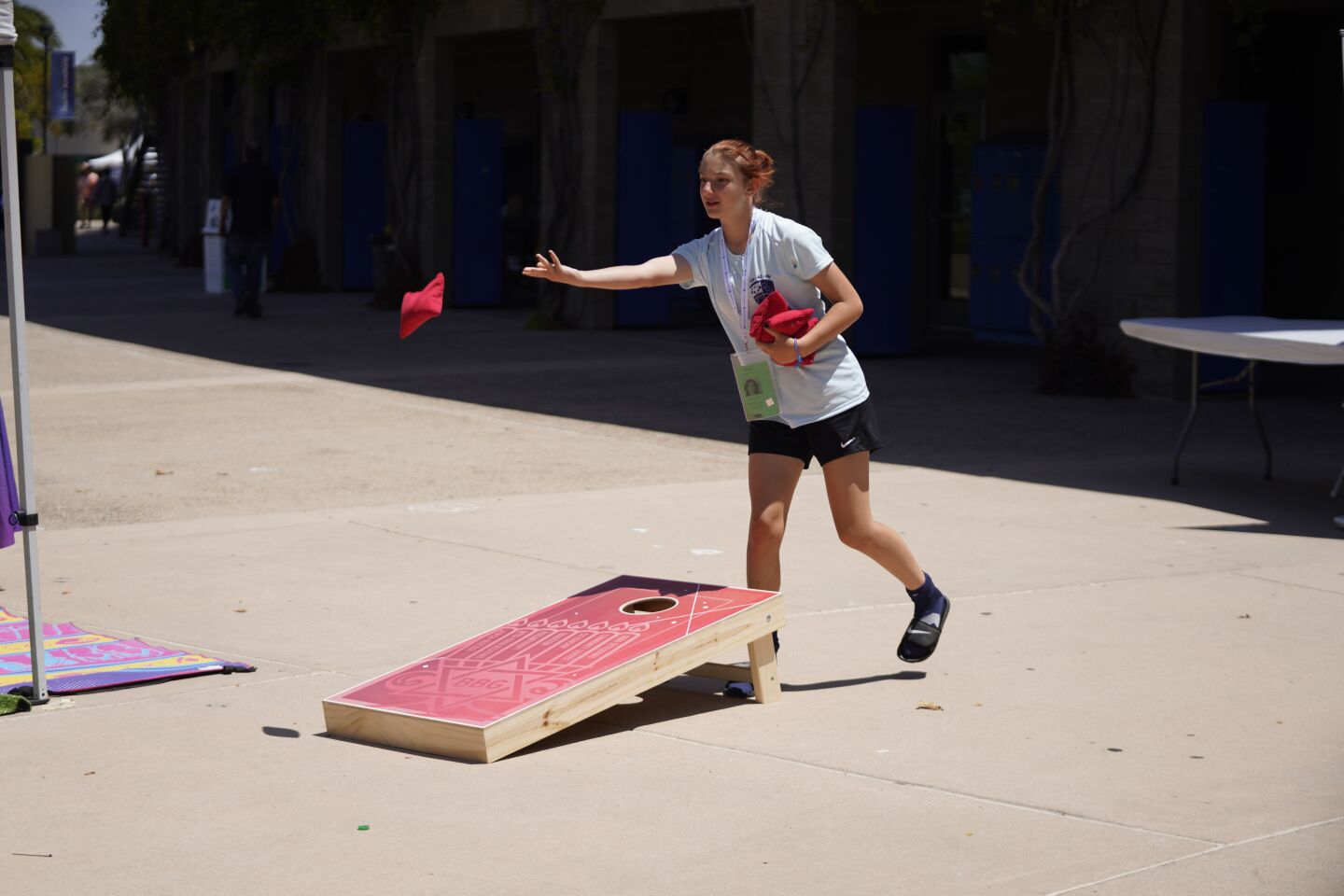A cornhole competitor plays during the Maccabi Games.