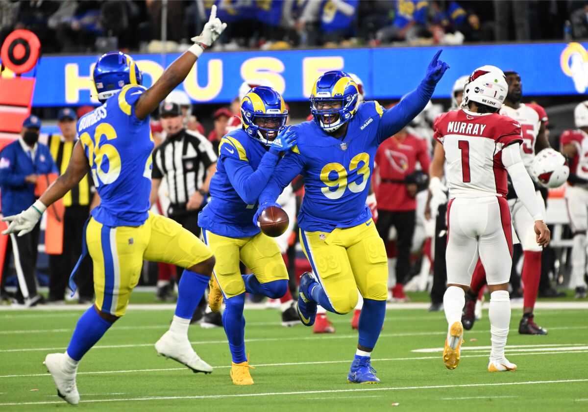 Rams defensive lineman Marquise Copeland (93) celebrates with teammates after intercepting a deflected pass.