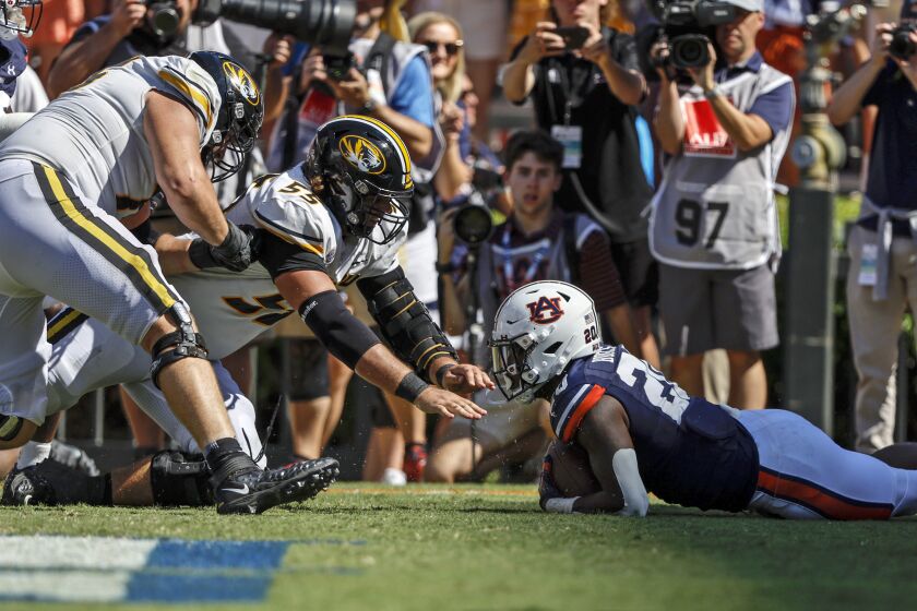 Auburn safety Cayden Bridges (20) recovers a fumble in the end zone to secure the win as Missouri offensive lineman Connor Tollison (55) reaches for the ball during overtime in an NCAA college football game, Saturday, Sept. 24, 2022 in Auburn, Ala. Auburn won in overtime, 17-14. (AP Photo/Butch Dill)
