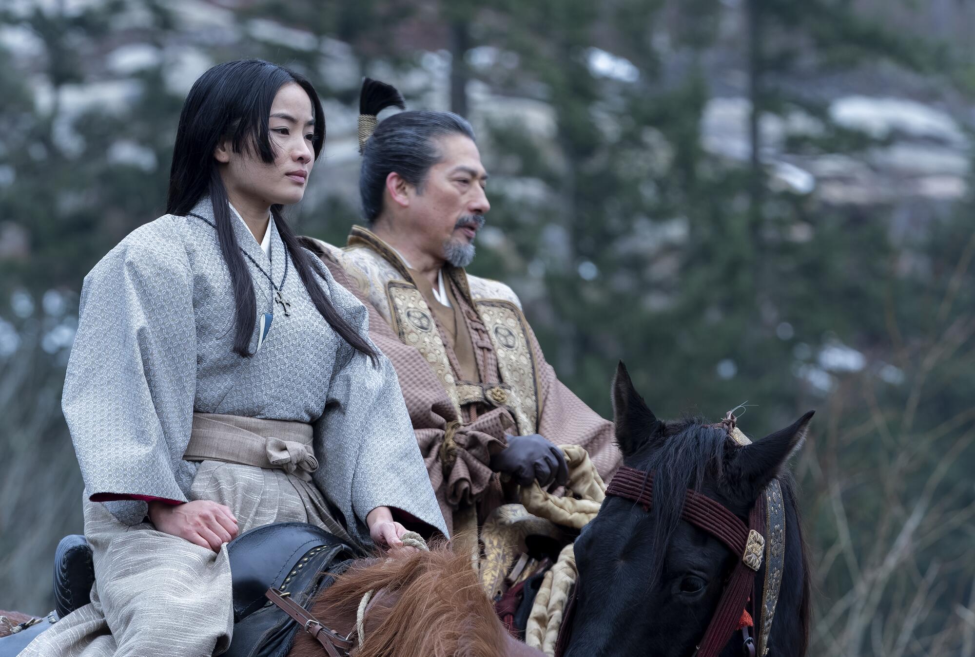 A woman and man in Japanese period attire riding horses