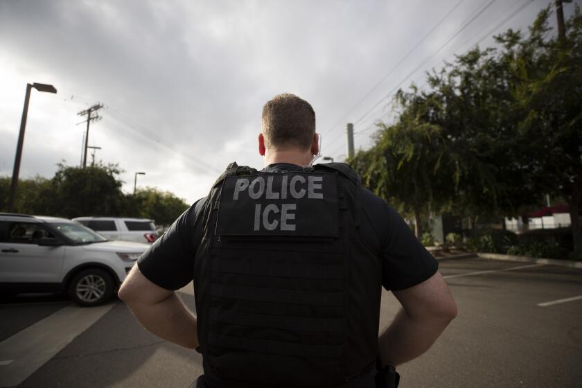 FILE - In this July 8, 2019, file photo, a U.S. Immigration and Customs Enforcement (ICE) officer looks on during an operation in Escondido, Calif. San Diego County Sheriff Bill Gore says he will comply with U.S. Immigration and Customs Enforcement's request for information on four people with criminal records, becoming the first state or local law enforcement official in the country to so honor such requests among a spate of jurisdictions whose laws sharply restrict cooperation with immigration authorities. (AP Photo/Gregory Bull,File)