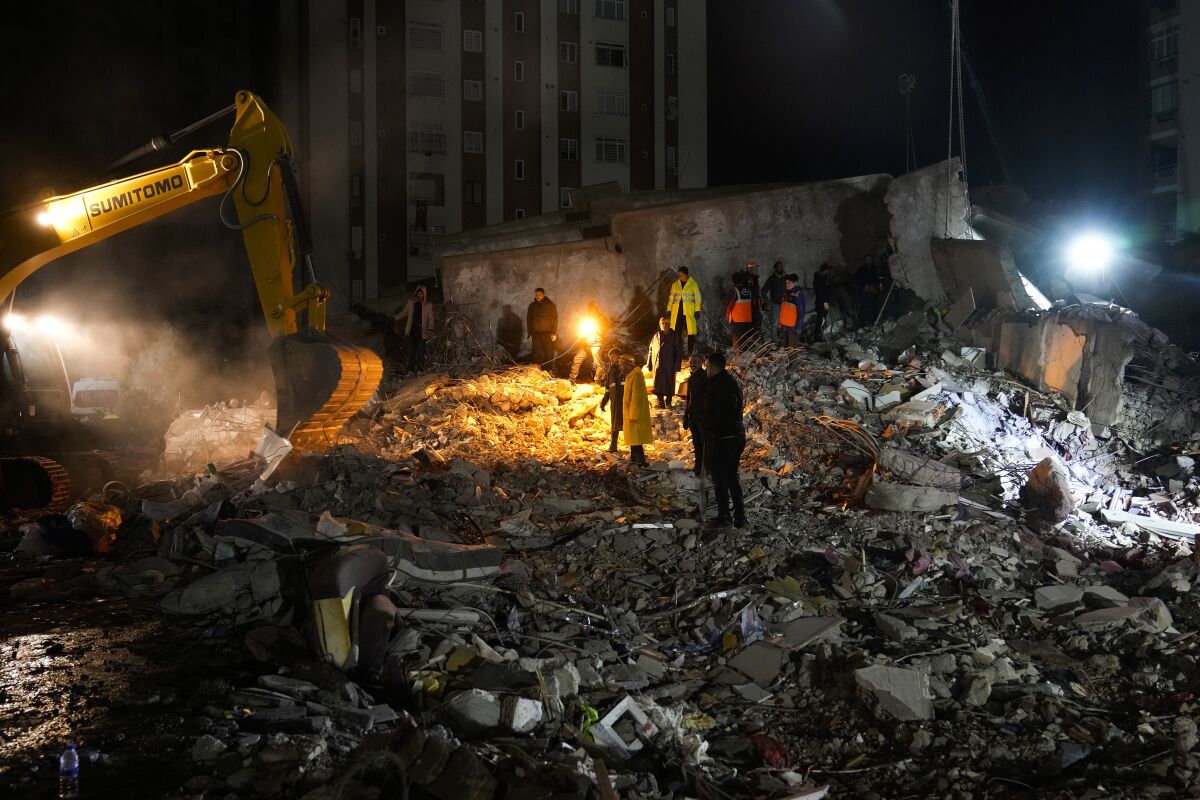 Equipos de emergencia buscan personas entre los escombros de un edificio destruido