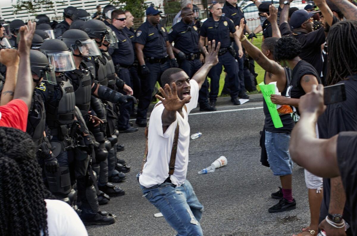 Un hombre intenta impedir que manifestantes se enfrenten a policías antimotines ante la comisaría de policía de Baton Rouge, luego de la policía intentara despejar la calle, en Baton Rouge, Louisiana, el 9 de julio de 2016. Varios manifestantes fueron detenidos. (AP Foto/Max Becherer)