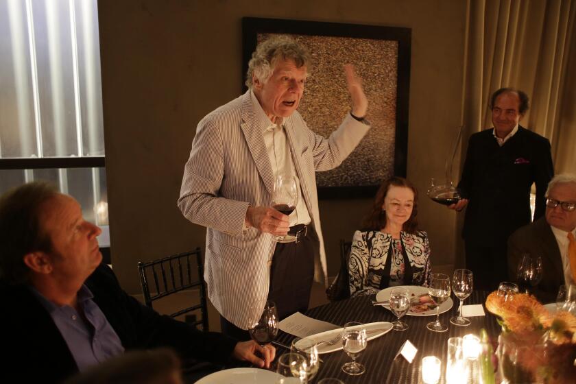 Gordon Getty gestures while speaking about wine bottle closures during an Auction Napa Valley vintners dinner as glass manufacturer Georg Riedel, second from right with decanter, looks on at Cade Estate winery Friday, May 31, 2013 in Angwin, Calif. Getty was expressing his support for the use of screw tops. Proceeds from the annual weekend event support community health and children's education. The event has given more than $111 million to dozens of these organizations. Getty is one of the owner's of the winery. At left is winery general manager John Conover. (AP Photo/Eric Risberg)