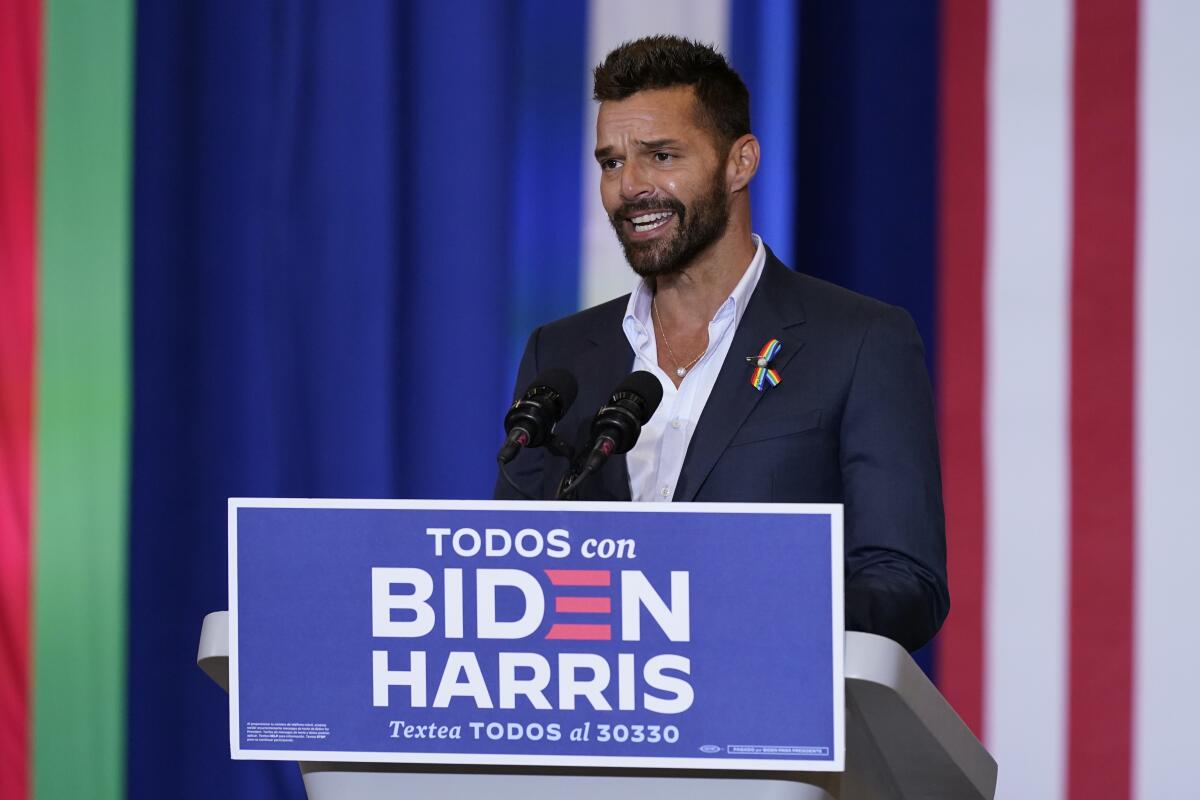 Pop star Ricky Martin speaks at a Biden event in Kissimmee, Fla., with a Spanish-language sign, "Todos con Biden-Harris."