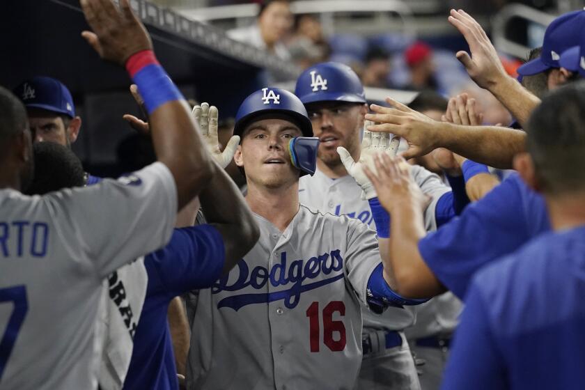 Los Angeles Dodgers' Will Smith (16) is congratulated by his teammates after hitting a home run in the third inning of a baseball game against the Miami Marlins, Monday, Aug. 29, 2022, in Miami. (AP Photo/Marta Lavandier)