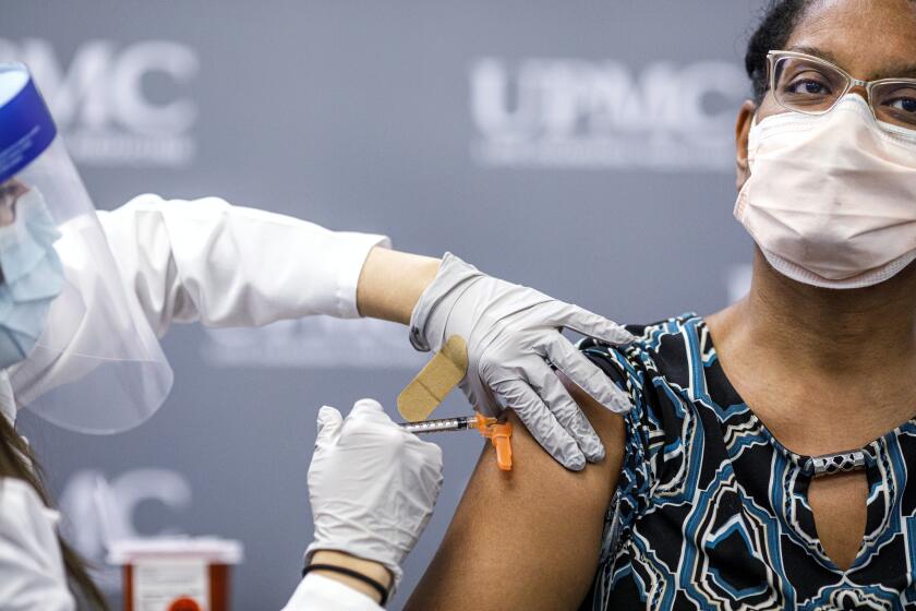 Jill Johnson adminsters the Pfizer COVID-19 vaccine to Sharee Livingston, an OB-GYN with UPMC Lititz. UPMC frontline workers receive the first doses of the Pfizer COVID-19 vaccine at UPMC Pinnacle Harrisburg hospital, December 18, 2020. (Dan Gleiter/The Patriot-News via AP)