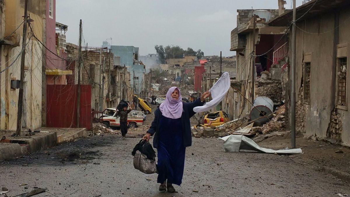 Jumah Diwan, 70, carries a white flag and a few belongings in a bag while fleeing the fighting in Mosul's Wadi Hajar neighborhood on Saturday.