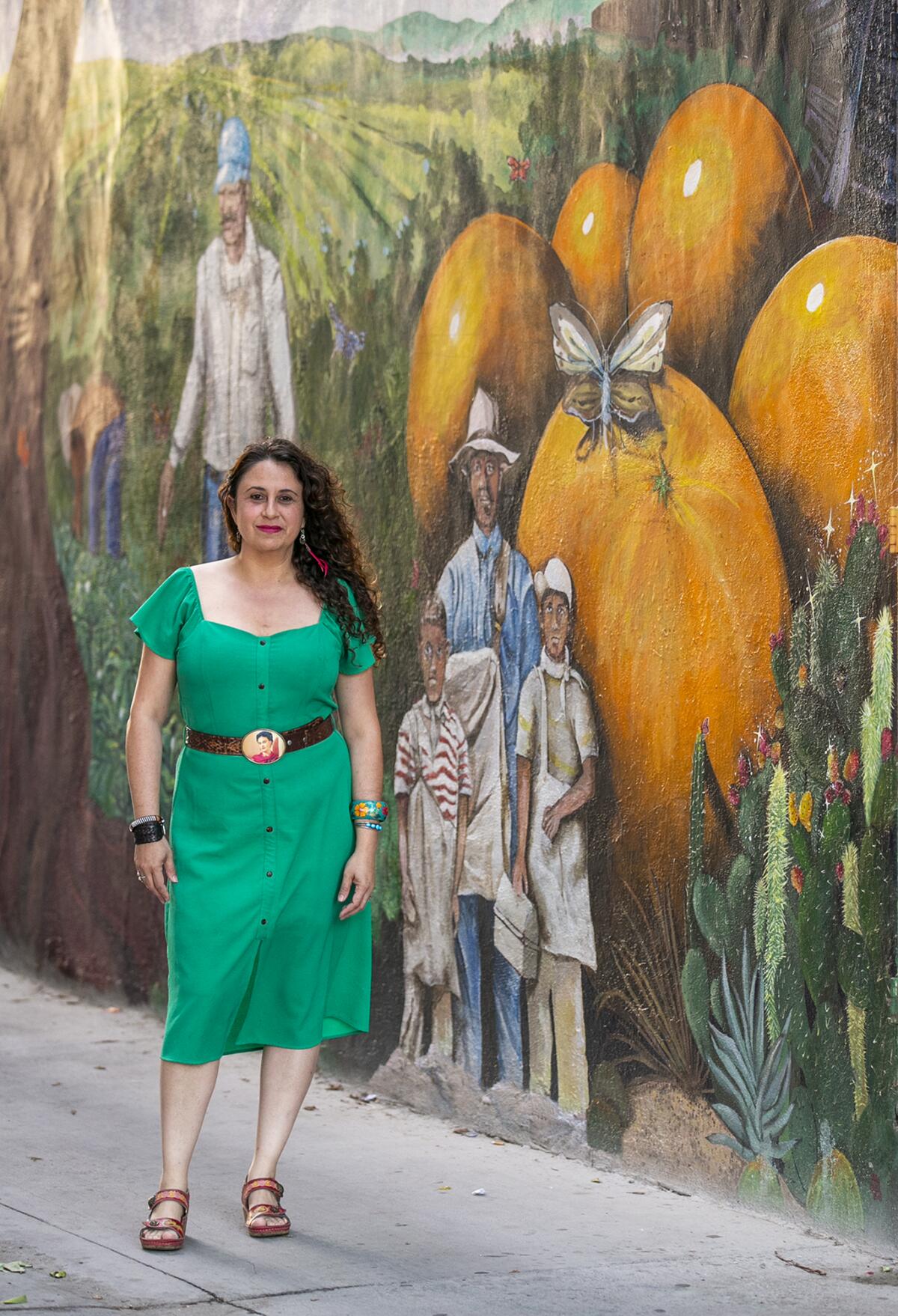 Rojas poses in Santa Ana's art alley, a mural project she led.