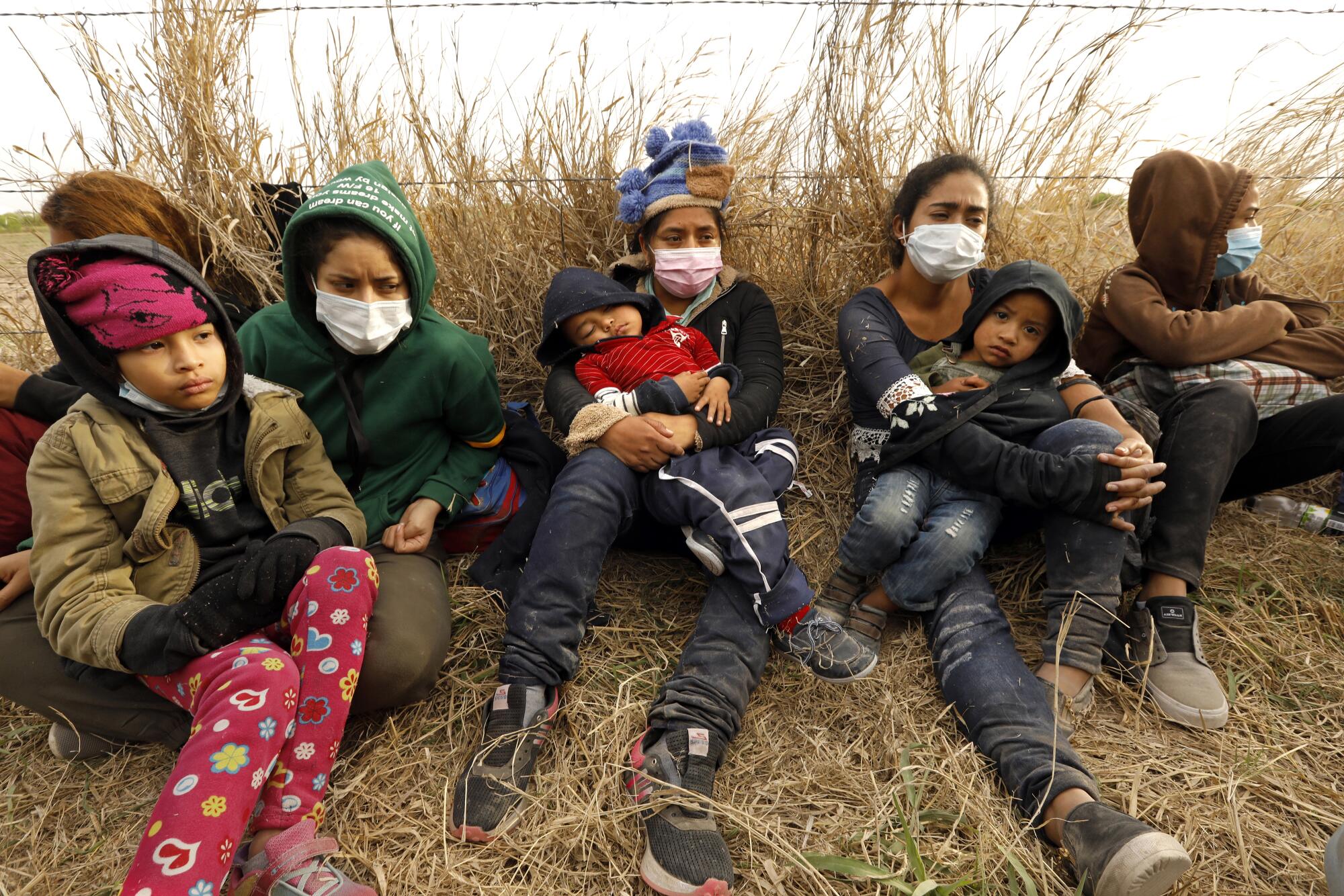 Asylum seekers rest on the ground.