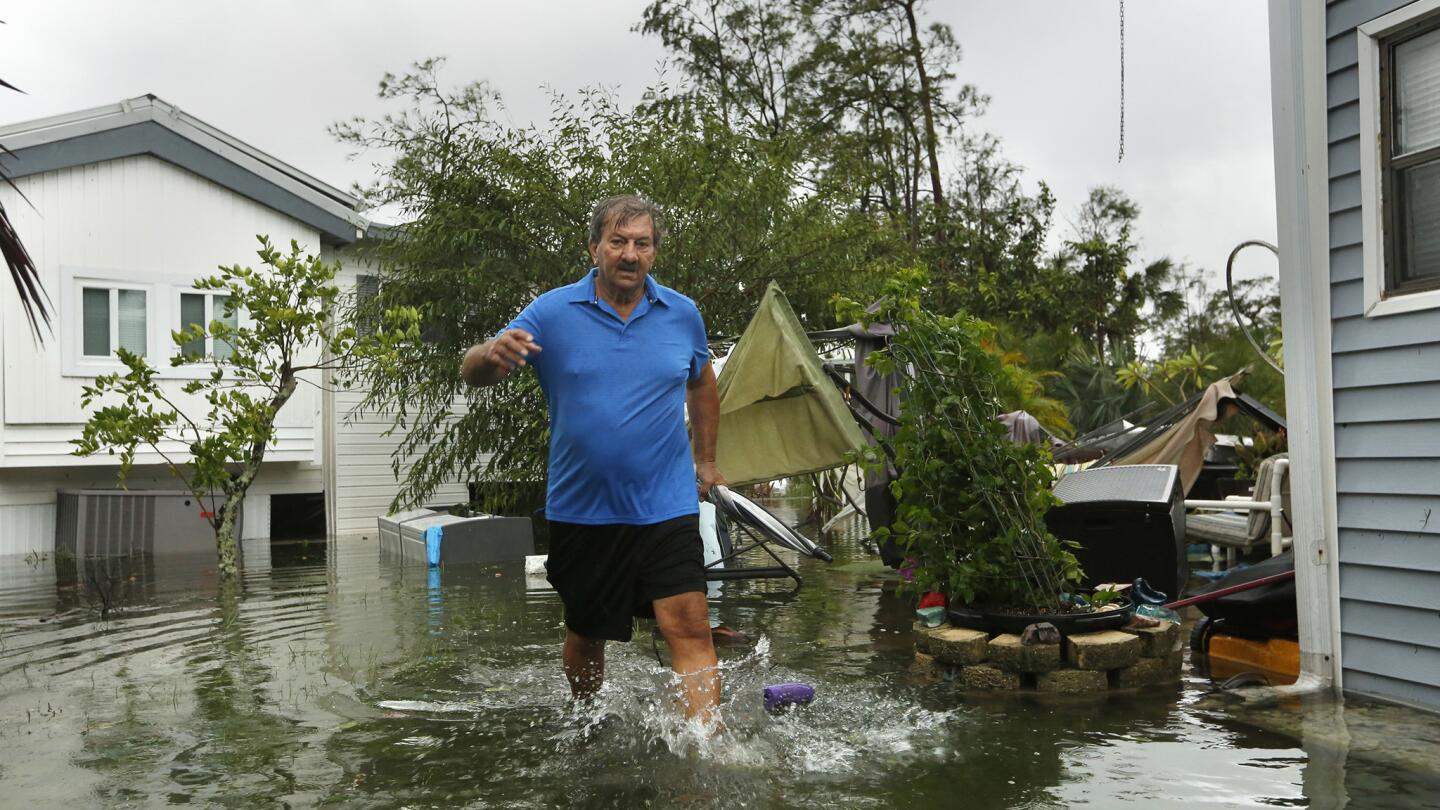John Krowzow, 74, wades in floodwater to check out his homes in Corkscrew Woodlands, a park with 640