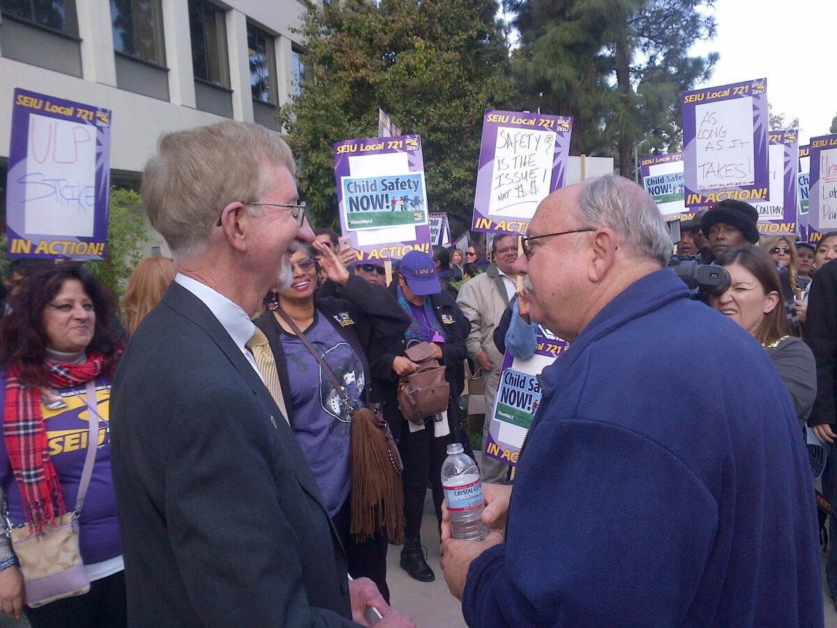 Los Angeles County child-welfare chief Philip Browning, left, appears at a rally for striking social workers. He asked that they return to work. At right is SEIU Local 721 President Bob Schoonover.