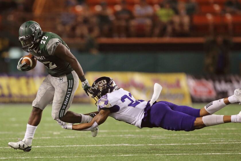 Western Carolina defensive back JerMichael White (22) trips up Hawaii running back Diocemy Saint Juste (22) during the third quarter of the NCAA college football game, Saturday, Sept. 2, 2017, in Honolulu. (AP Photo/Marco Garcia)