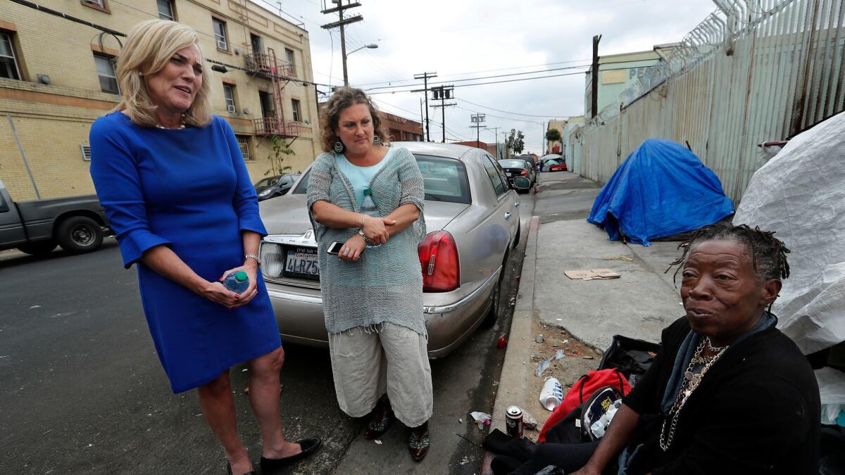 Los Angeles County Supervisor Kathryn Barger, left, and Dr. Susan Partovi, medical director of Homeless Health Care Los Angeles, talk with Deborah Bailey, who is homeless.