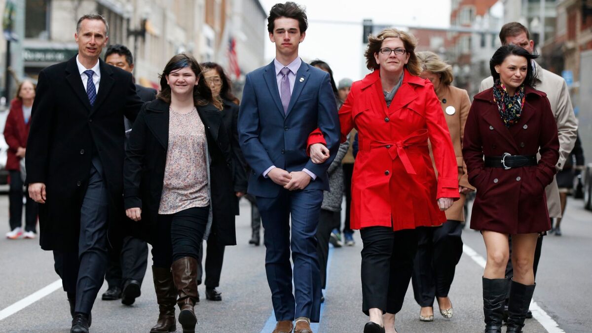 The family of Martin Richard — from left, Bill, Jane, Henry and Denise — walk down Boylston Street after a ceremony Sunday at the site where 8-year-old Martin was killed in an explosion at the 2013 Boston Marathon.