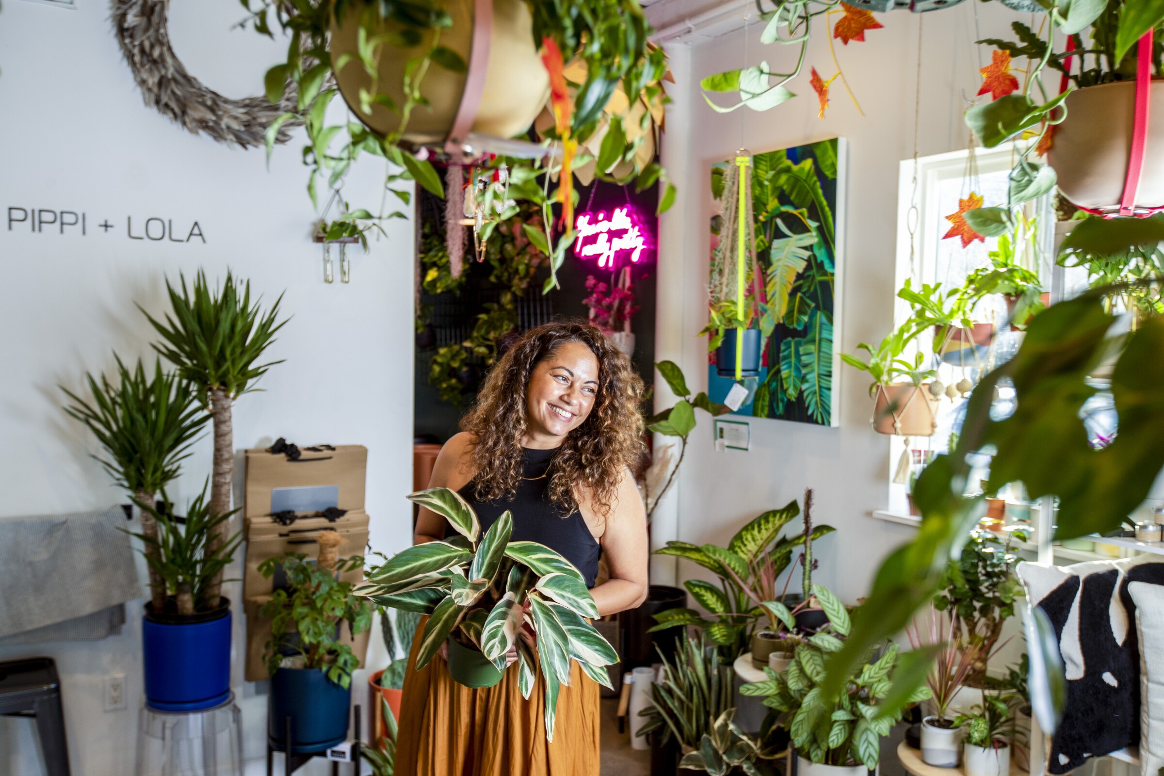 Dynelly del Valle in her plant shop, surrounded by plants. 