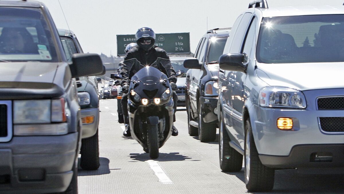 Motorcyclists drive between lanes of cars on the 405 Freeway in Long Beach in 2007.