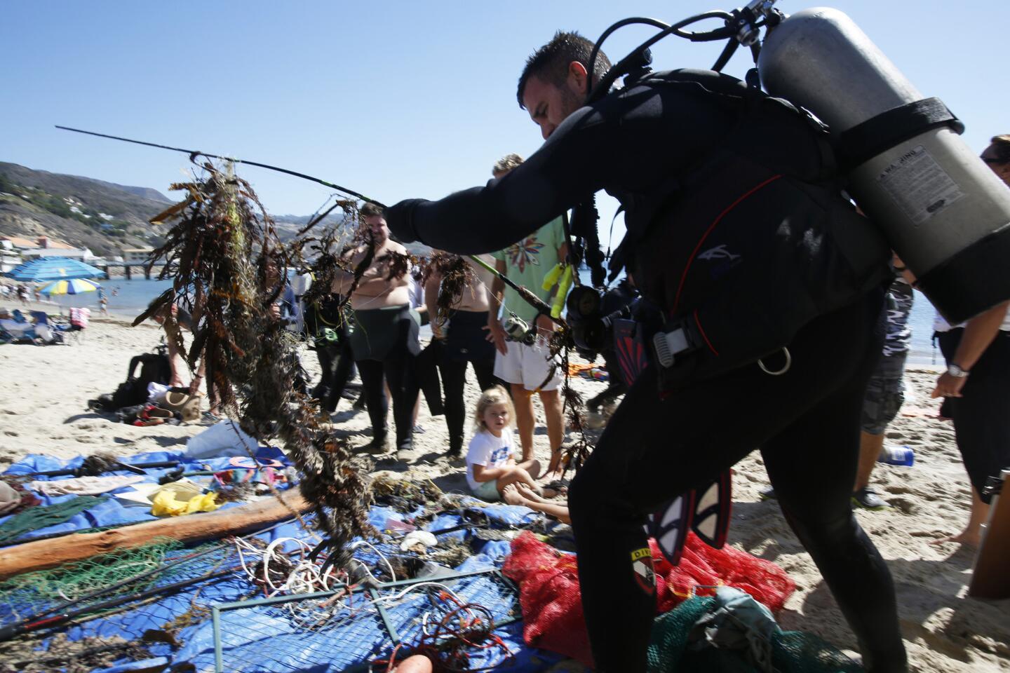 Jason Zigler lays down a fishing pole along with the 15 pounds of trash he found during Coastal Cleanup Day in Malibu.