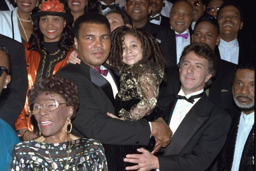 Boxing legend Muhammad Ali, shown holding young actress Raven-Symone, center, poses for a group photograph prior to a celebration of his 50th birthday in Los Angeles.