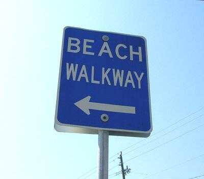 Blue signs point out beach access points.