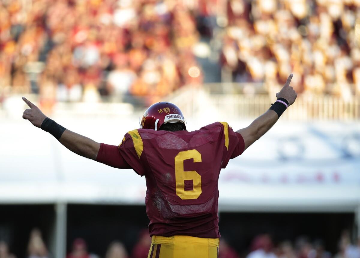 Cody Kessler raises his arms after his USC-record seventh touchdown pass is confirmed by replay officials Saturday during the Trojans' 56-28 victory over Coloroado at the Coliseum.