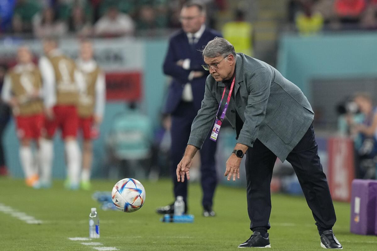 El técnico de México Gerardo Martino retorna el balón al campo de juego durante el partido contra Polonia 