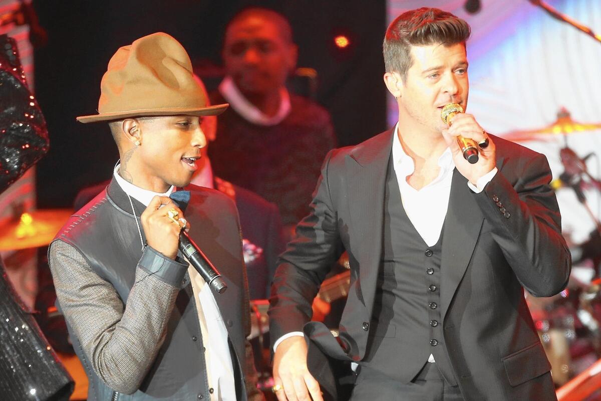 Recording artists Pharrell Williams, left, and Robin Thicke perform at the Beverly Hilton on Jan. 25, 2014.