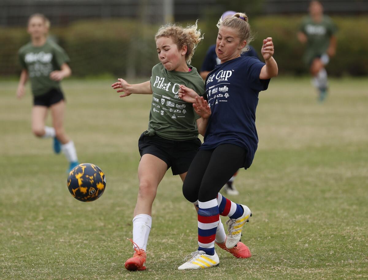 Mariners Elementary's Payton Williams, left, battles for the ball with Newport Heights Elementary's Peyton Bodas in a girls' sixth-grade Gold Division match at the Daily Pilot Cup in Costa Mesa on May 29, 2018.