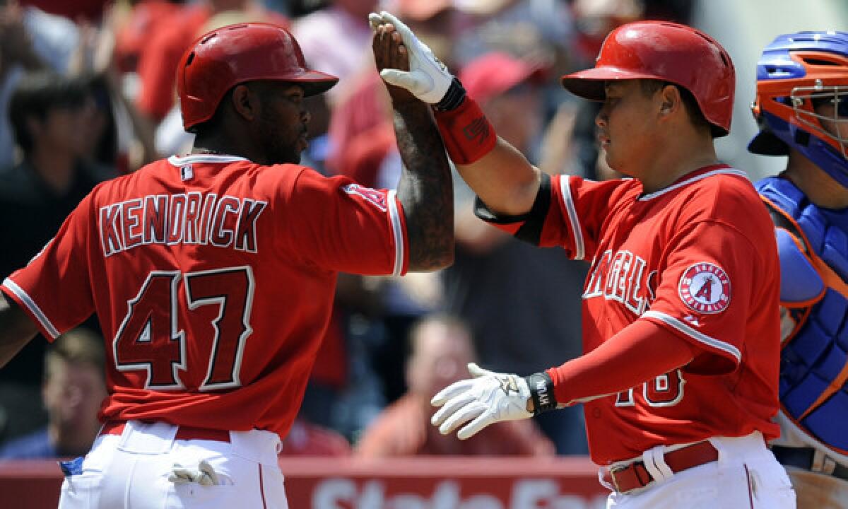 Angels catcher Hank Conger, right, is congratulated by teammate Howie Kendrick after hitting a two-run home run during the fifth inning of the Angels' 14-2 victory over the New York Mets on Sunday.